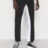 Pegador DEMERE WIDE TRACK PANTS UNISEX - Jogginghose - Black/white -Indicode Jeans Verkäufe 4eca3e509d724ae2a5e073e1715eeac2